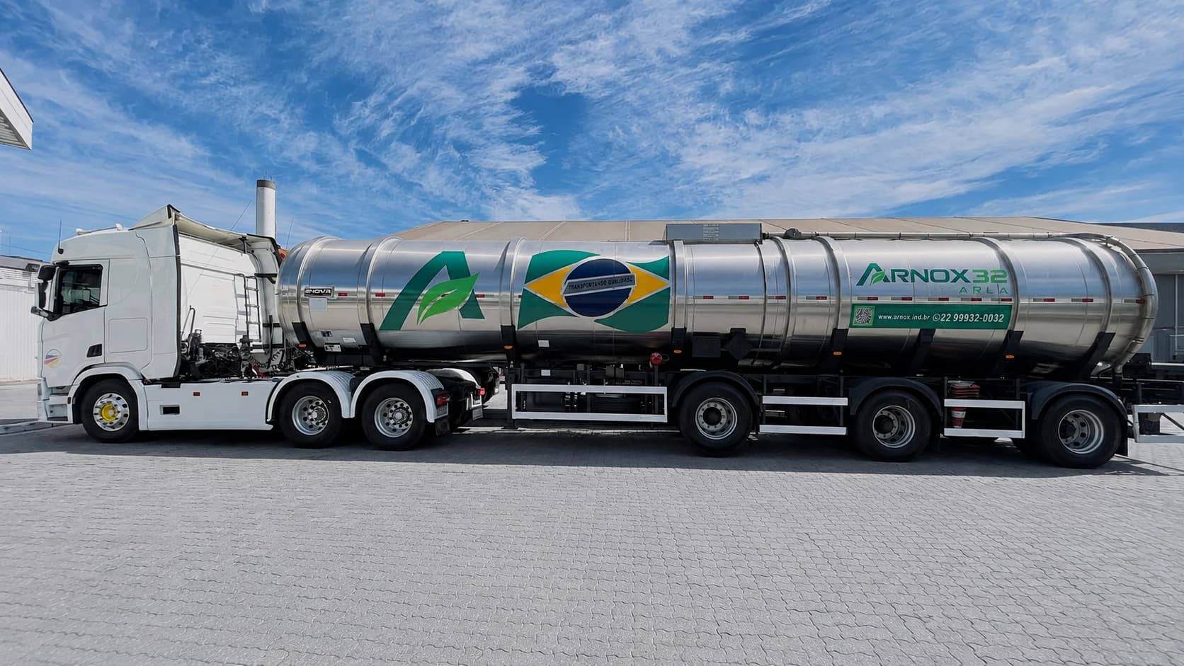 Caminhão-tanque ARNOX 32 com adesivo da bandeira do Brasil, vista lateral com céu azul ao fundo